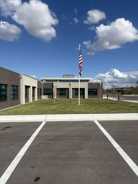 Mowed lawn in front of a commercial building with a flagpole