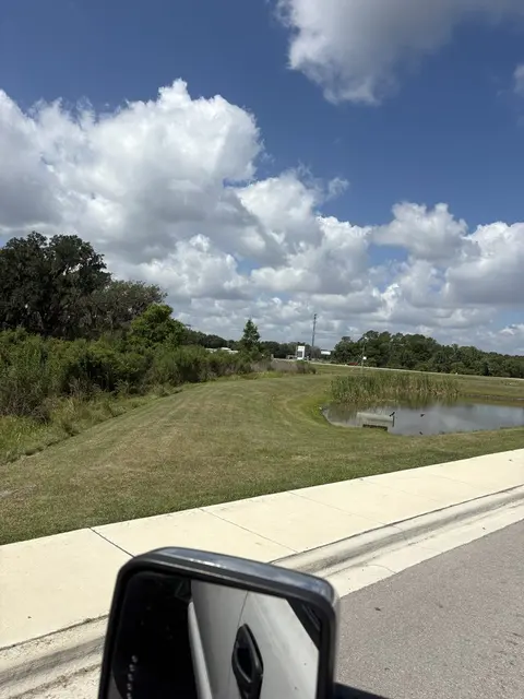 Mowed slope down to a retention pond beside a sidewalk