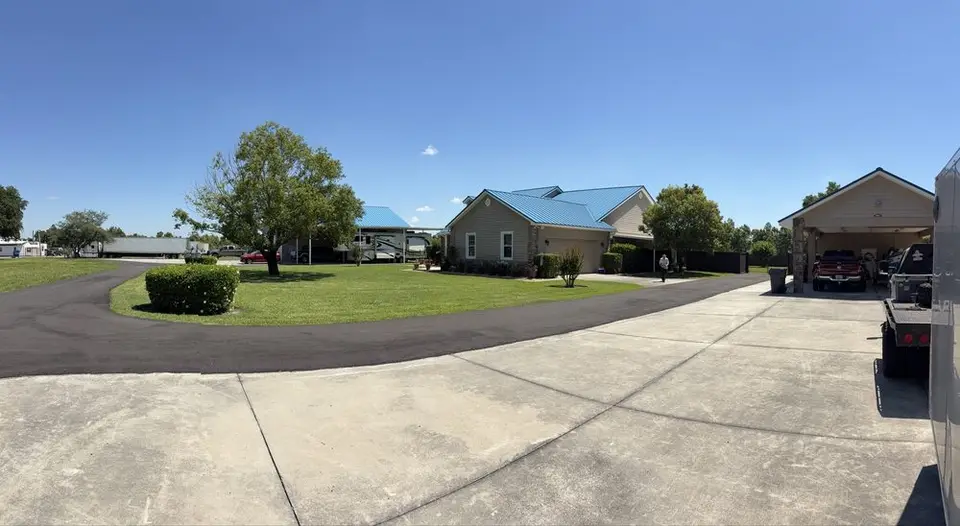 Wide view of a freshly mowed property with a circle drive and trimmed shrubs